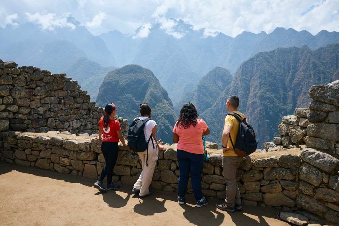 Intrepid group and leader look out over the mountains of Peru at Machu Picchu