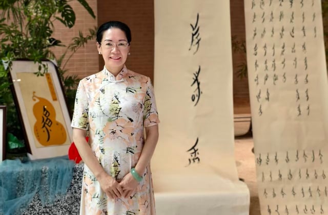 A woman standing in front of nushu script