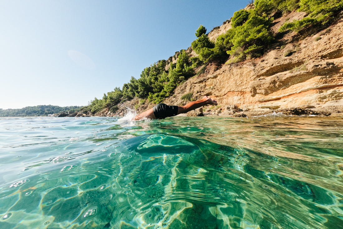Intrepid traveller dives off submerged rock into the Aegean Sea off the coast of Alonnisos in the Sporades archipelago in Greece