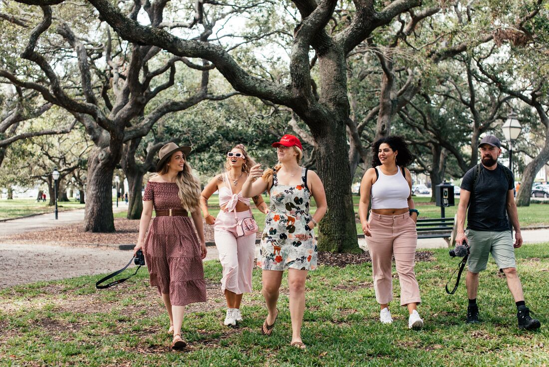 Group with leader in red hat walk around Charleston's parks with happy smiles