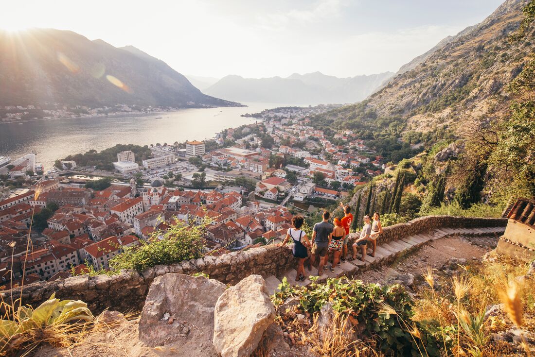 Travellers enjoying the view with a leader who is pointing off in the distance in Kotor, Montenegro