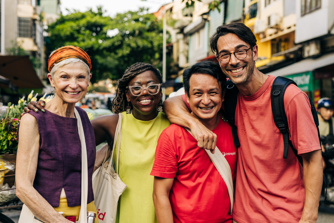 Intrepid leader and travellers of varied age stopping for a photo on the streets of Hanoi