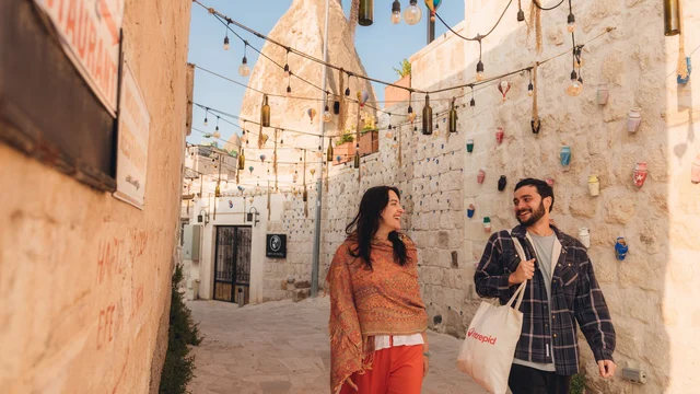 Two travellers walk along a street in Cappadocia, Turkey.