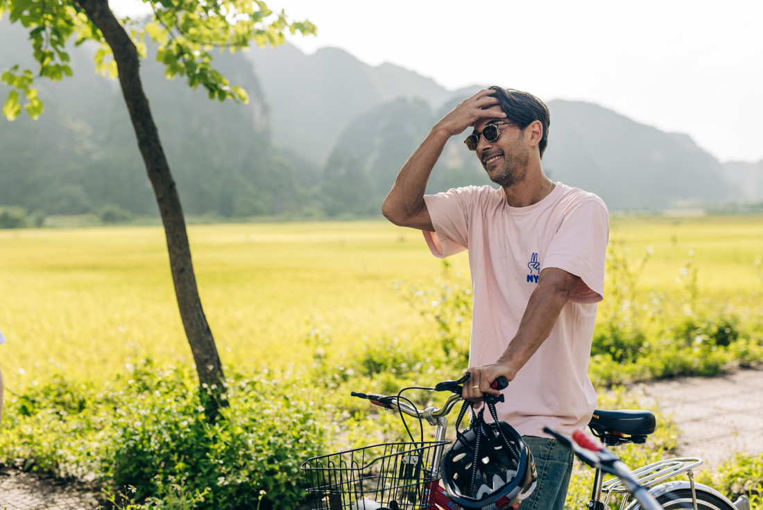 Traveller fixes hair after a long bicycle ride in the countryside of Ninh Binh
