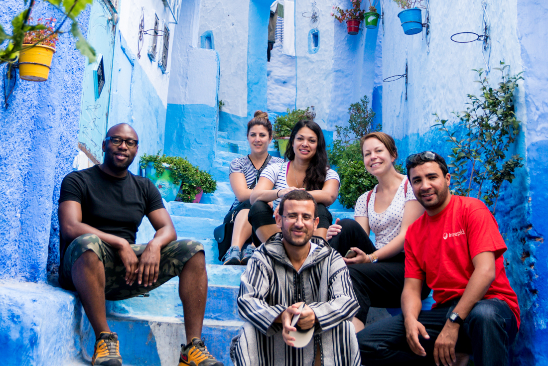 Travellers and leader pose for group shot in Chefchaouen's blue streets
