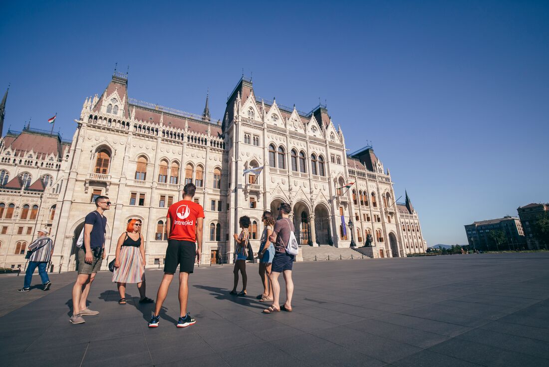 18 to 35s travellers listen to a talk from Intrepid leader outside Hungarian Parliament in Budapest on sunny day
