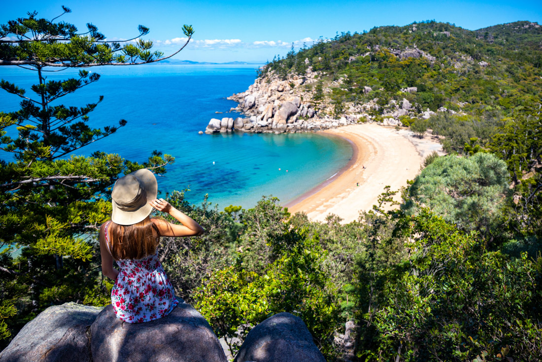 Traveller in sun hat looks out at Magnetic Island Beach