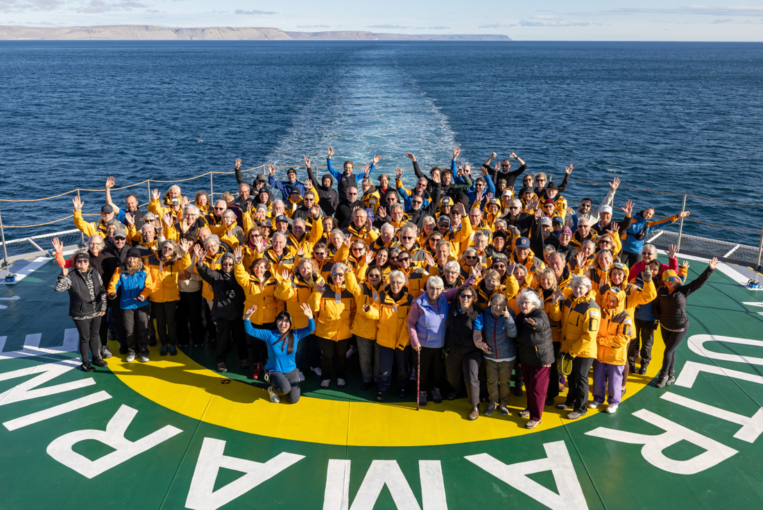 Traavellers and crew pose for a group shot on the Ultramarine helipad 