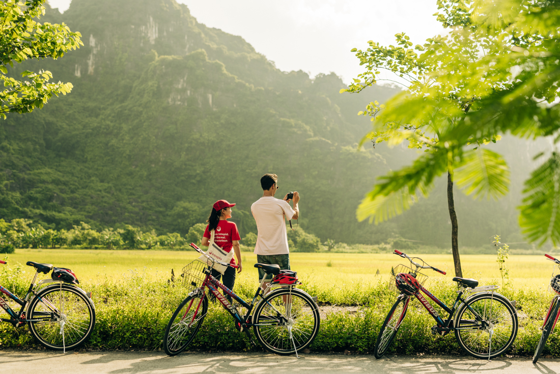 Intrepid traveller and leader stop for a photo of green hilled landscape 