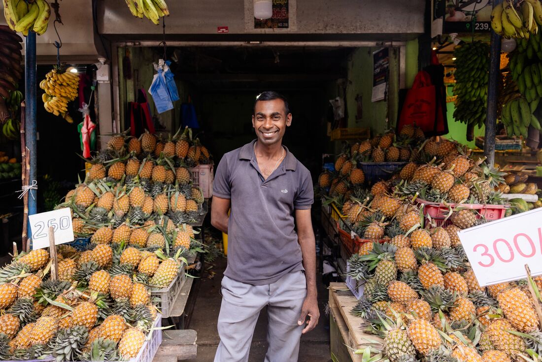 Smiling vendor at local fruit market stall in Kandy, Sri Lanka