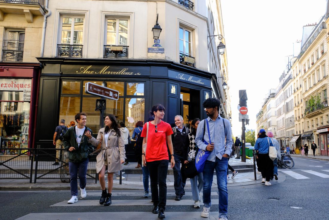 Intrepid group with leader talking to traveller exploring the streets of Marais in Paris, France