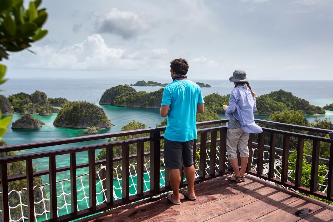 Travllers taking in the view of Piaynemo Islands in Indonesia