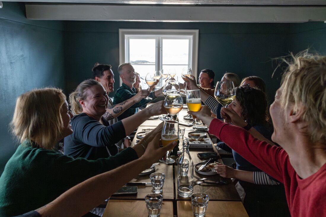 A celebratory cheers over dinner at the Ilimanaq lodge