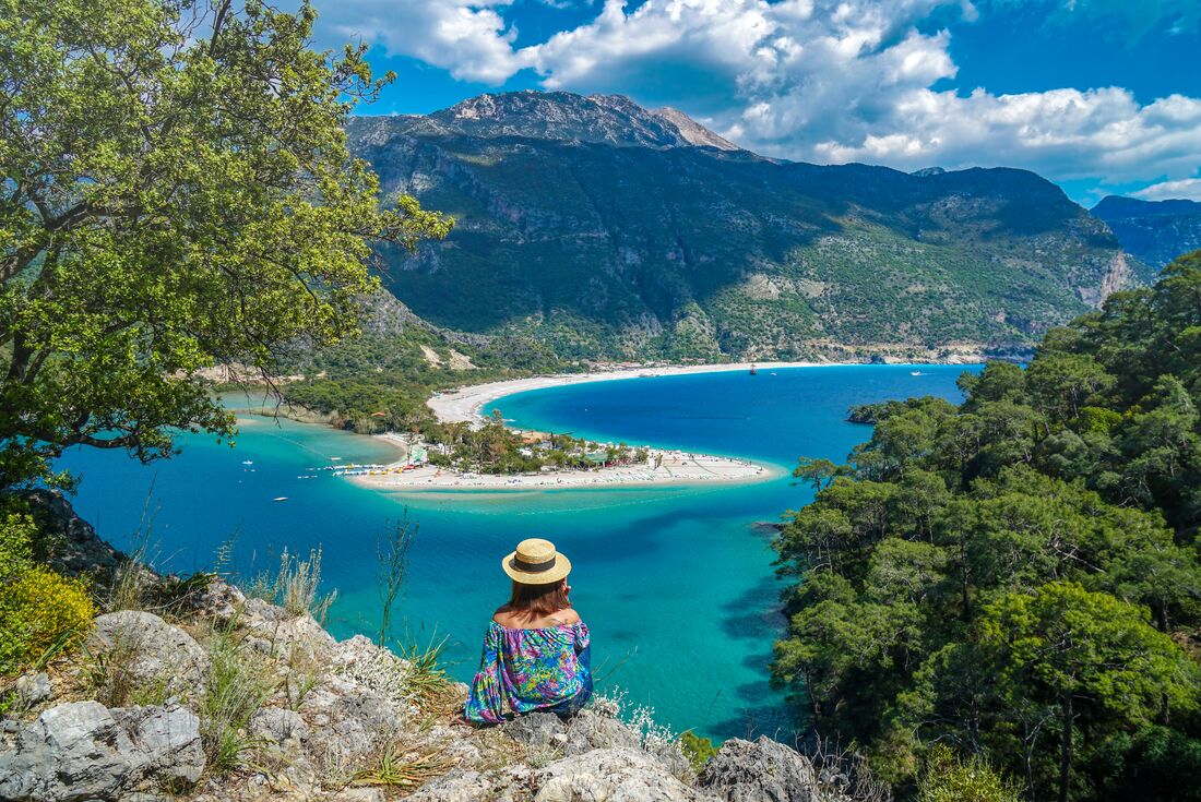Woman stops on walk on the coast of Turkey to look at penninsula of Fethiye town