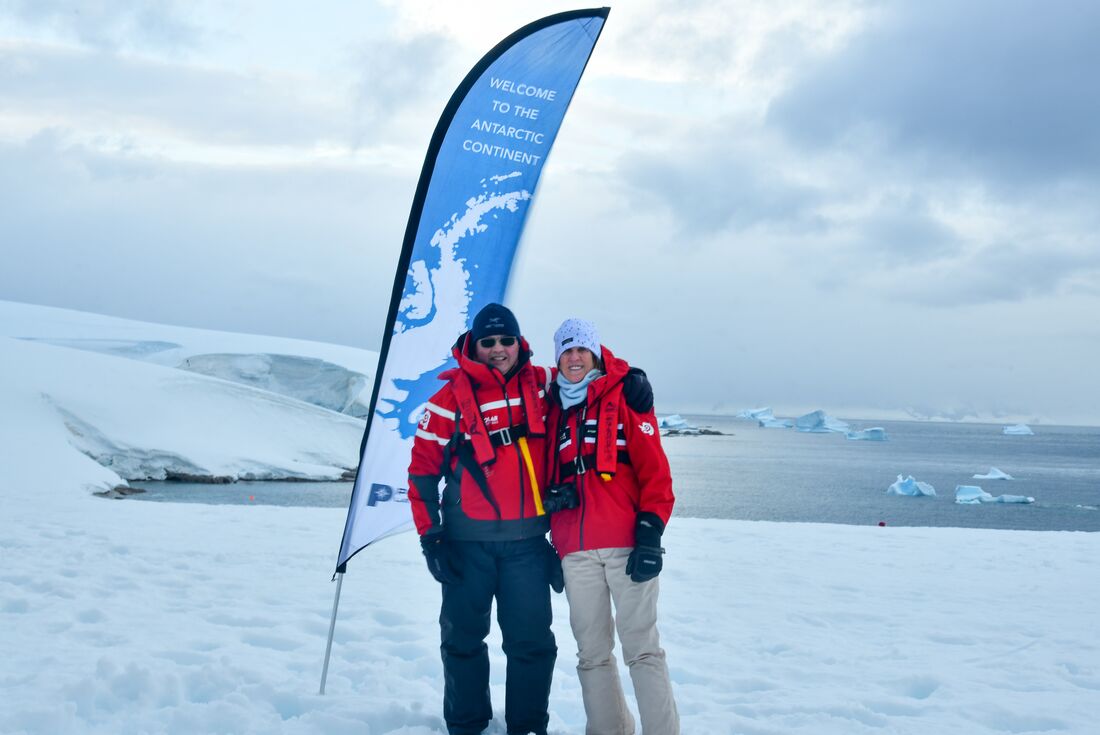 Travellers embrace happily at the landing of Portal Point in northern Antarctica
