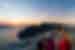 Intrepid travellers and leader look out at sunset over the Aegean Sea from a Santorini balcony