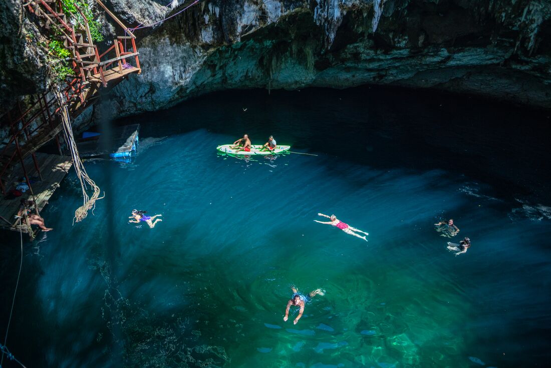 High POV of travellers enjoying a cenote, swimming and in boats, Mexico