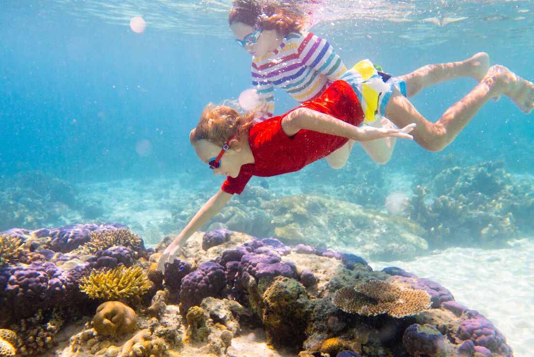 Family fun snorkeling at coral reef, Borneo