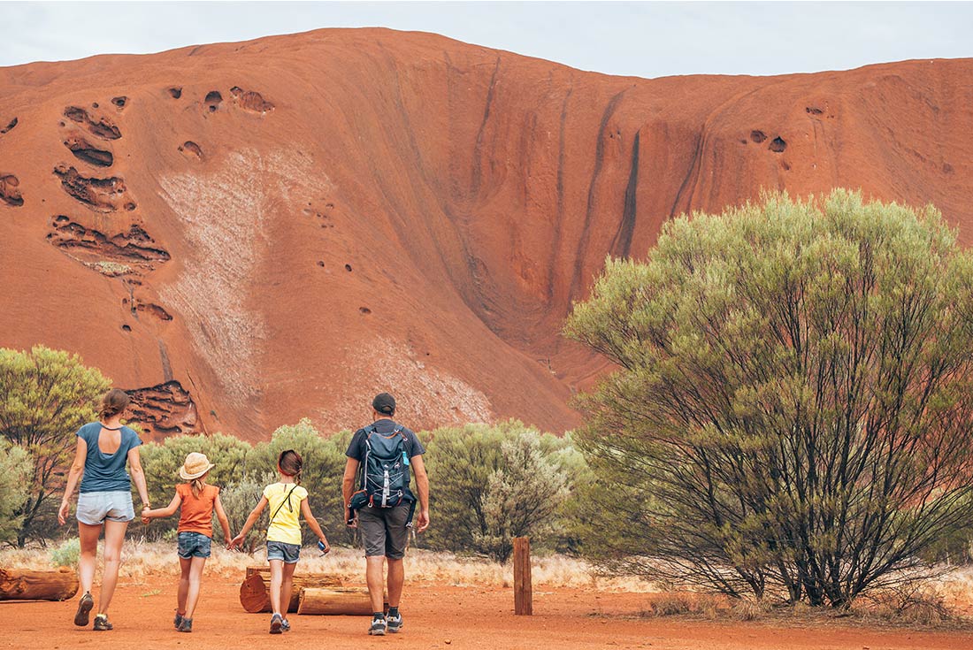 Family hand in hand while walking through the Red Centre, Australian Outback