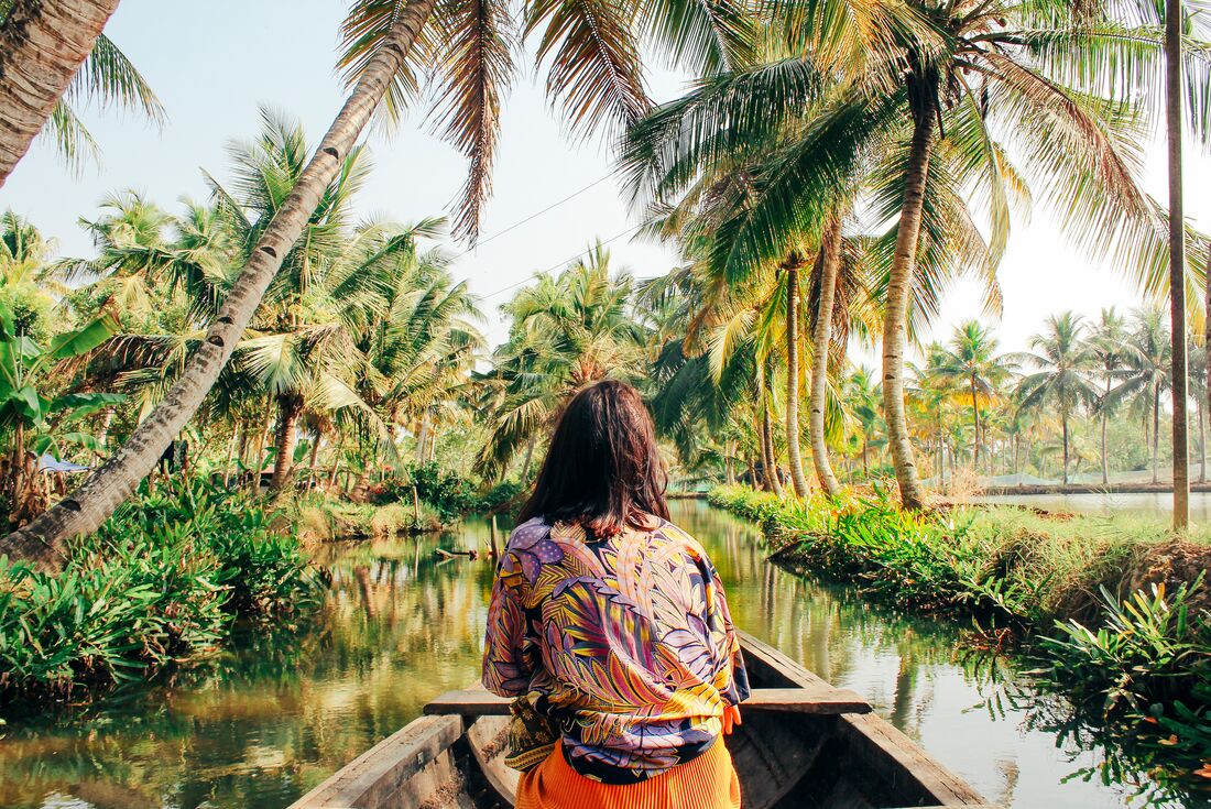 Traveller cruising on small river boat in Kerala Backwaters in southern India