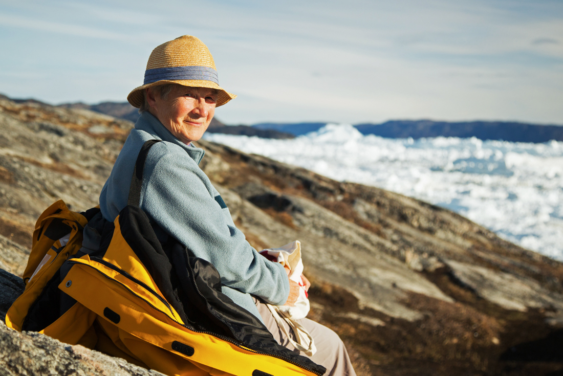 Traveller looks at camera while relaxing at Sisimiut near Ilulissat