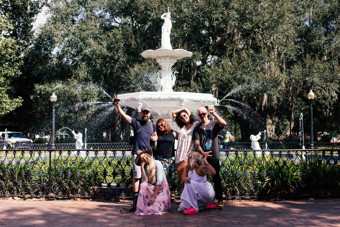 Travellers pose for a group shot in front of the Forsyth Park Fountain in Savannah Georgia USA