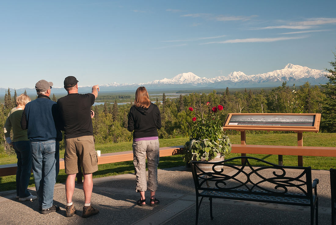 Travellers viewing mountain range in Talkeetna, Alaska, U.S.A.